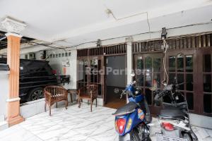 a scooter parked in a garage with a table and chairs at Danysa Guest House Jakarta RedPartner in Jakarta