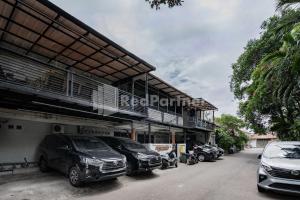 a parking lot with cars parked next to a building at Danysa Guest House Jakarta RedPartner in Jakarta