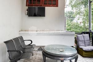 a room with a table and a chair and a tv at Danysa Guest House Jakarta RedPartner in Jakarta