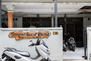 a scooter parked in front of a building with a sign at Danysa Guest House Jakarta RedPartner in Jakarta +12 photos