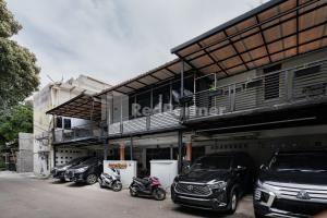 a row of parked cars parked in front of a building at Danysa Guest House Jakarta RedPartner in Jakarta