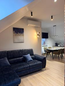 a living room with a couch and a dining room at Hotel Chrobrego9 in Bolesławiec