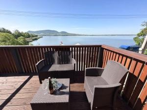 a deck with two chairs and a table with a view of the water at Penzion Šedivý in Strachotín