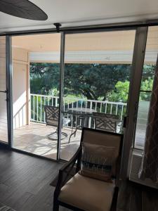 a screened in porch with a chair and a balcony at The Happy Hideaway - Maui Calm by the Ocean in Kihei