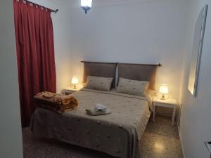 a bedroom with a large bed with two tables and two lamps at Casa Mima in Tétouan