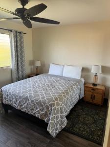 a bedroom with a bed and a ceiling fan at The Happy Hideaway - Maui Calm by the Ocean in Kihei