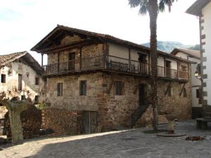 an old stone building with a balcony on top of it at Albergue Olasenea Aterpea in Zubieta