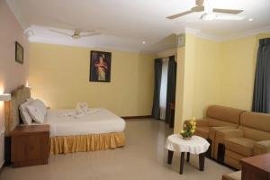 a hotel room with a bed and a couch at Veliyil Towers in Alleppey