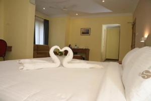two swans shaped like hearts sitting on top of a bed at Veliyil Towers in Alleppey +2 photos