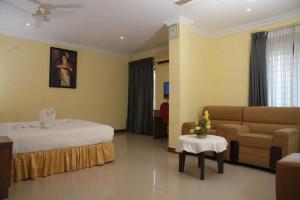 a hotel room with a bed and a couch at Veliyil Towers in Alleppey