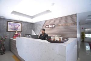 a woman sitting at a counter in a lobby at Veliyil Towers in Alleppey