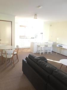 a living room with a couch and a table and chairs at Acorn Lodge in Bright