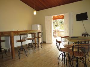 a kitchen with tables and chairs and a refrigerator at Chalé da Serra in São João del Rei