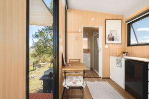 a small kitchen with a table and a window at Kanimbla Sunsets by Tiny Away in Kanimbla