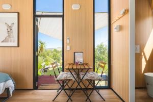 a room with a table and chairs and a door with a view at Kanimbla Sunsets by Tiny Away in Kanimbla +17 photos