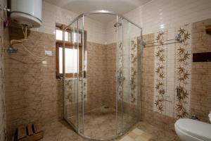 a shower with a glass door in a bathroom at Ishan Log Huts-A boutique home stay in Banjār