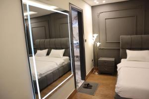 a mirror in a small room with two beds at Bahria Premium Hotel in Rawalpindi +99 photos