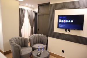 a waiting room with two chairs and a flat screen tv at Bahria Premium Hotel in Rawalpindi