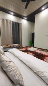 two beds in a room with white sheets at Amigo's Hotel and Restaurant in Nandaprayāg