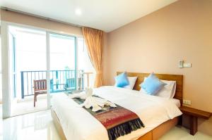 een slaapkamer met een groot bed en een groot raam bij G Residence in Pattaya South