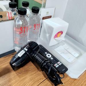 a remote control sitting on a table next to two water bottles at 9TY hotel (ninety hotel) in Bangkok +38 photos