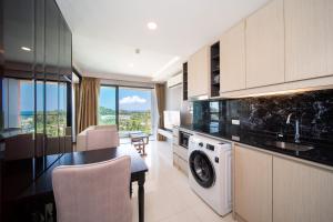 a kitchen with a washing machine and a dining room at Private Residents in Surin Mida in Surin Beach