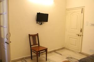 烏代浦的住宿－普拉塔普巴哈旺酒店，一间带椅子和墙上电视的房间