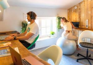 a man and a woman sitting in an office at SURF HOSTEL BIARRITZ in Biarritz