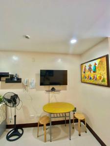 a room with a table and a tv on a wall at LG-15B City Center Staycation at Megatower 1 in Baguio