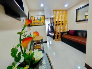 a living room with a couch and a table with flowers at LG-15B City Center Staycation at Megatower 1 in Baguio +2 photos