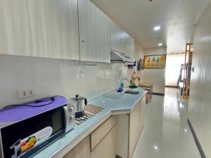 a kitchen with a sink and a microwave at LG-15B City Center Staycation at Megatower 1 in Baguio
