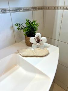 a white bathroom sink with a towel and a plant at Ferienwohnung Joanna in Norddeich +59 photos