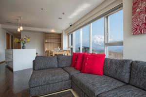 a living room with a couch with red pillows at Snow Crystal in Kutchan