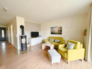 a living room with a yellow couch and a tv at Ferienwohnungen PerlePlau in Plau am See