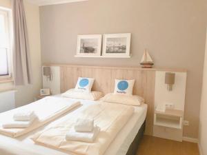 a bedroom with a large white bed with two pillows at Ferienwohnungen PerlePlau in Plau am See