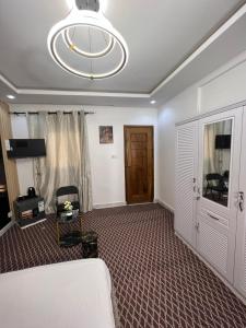 a living room with a bed and a chandelier at FASARESIDENCE Dakar Point E CHAMBRE NOFLAYE in Dakar