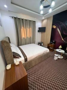 a hotel room with a bed and a table at FASARESIDENCE Dakar Point E CHAMBRE NOFLAYE in Dakar