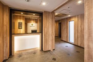 a hallway with wood paneled walls and a white sign at Flexstay Inn Sakuragicho in Yokohama