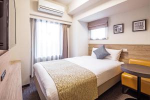 a hotel room with a bed and a table at Flexstay Inn Sakuragicho in Yokohama