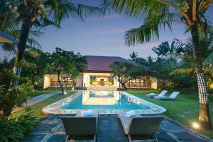 a backyard with a swimming pool and a house at Sativa Villas Ubud with Private Pool in Ubud
