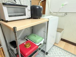 a kitchen with a microwave and two suitcases on a shelf at Okayama Urban Peach in Okayama +17 photos