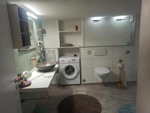 a bathroom with a washing machine and a sink at Ferienhaus Laila in Hochstetten-Dhaun +12 photos