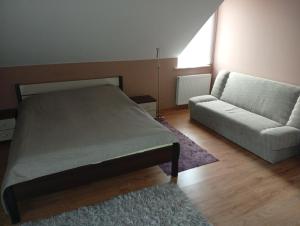 a bedroom with a bed and a couch at Dom na Konwaliowej in Narew