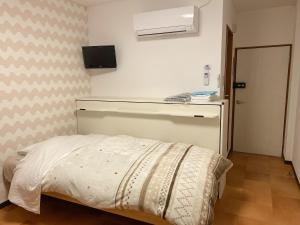 a small bedroom with a bed in a room at Pension Yumigahama in Minamiizu