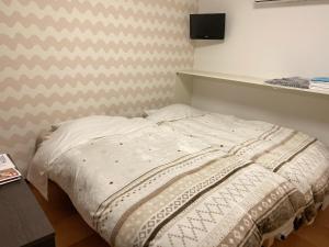 a bed in a room with a wall at Pension Yumigahama in Minamiizu