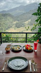 a wooden table with plates of food on it with a view at Eco Vibe Resort in Rattota