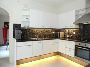a white kitchen with white cabinets and appliances at Quaint Villa in Doornspijk with Swimming Pool in Doornspijk