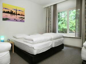 a bedroom with two beds and a painting on the wall at Quaint Villa in Doornspijk with Swimming Pool in Doornspijk