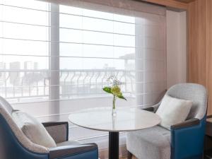 a living room with chairs and a table and a window at Hamamatsu Marriott Hotel in Hamamatsu