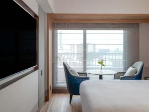 a room with a bed and a table and a window at Hamamatsu Marriott Hotel in Hamamatsu